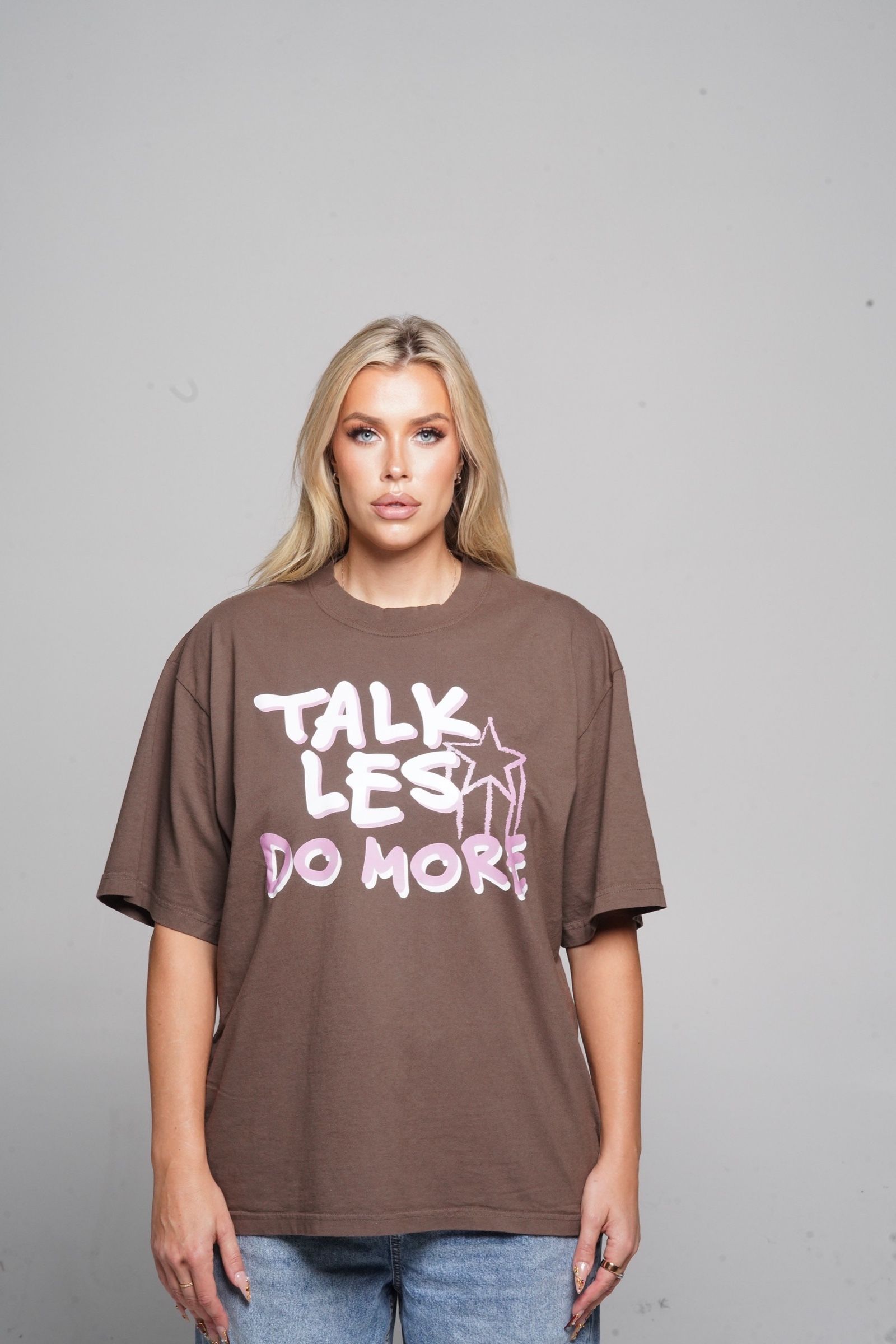 Les in the oversized mocha Talk Les. Do More. tee and wide-leg denim